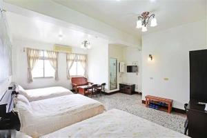 een slaapkamer met 2 bedden, een bureau en een televisie bij Plum Inn 2 in Jiji