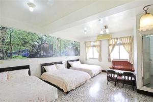 een slaapkamer met 2 bedden, een spiegel en een piano bij Plum Inn 2 in Jiji