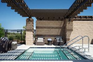 a pergola with chairs and a swimming pool at SpringHill Suites by Marriott Milpitas Silicon Valley in Milpitas