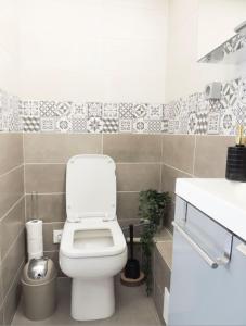 a bathroom with a toilet and a sink at Le Cocon de Poissy in Poissy