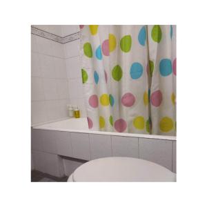 a bathroom with a toilet and a shower curtain with polka dots at Potamolithos Suites 2 in Konitsa