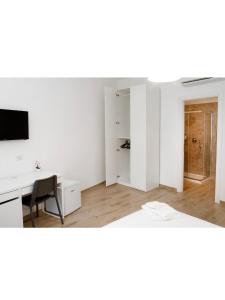 una camera bianca vuota con scrivania e computer di B&b CasaCapaldo a Napoli