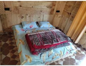 a bedroom with a bed with a blanket on it at Sandeep Home stay, Chakrata in Chakrāta