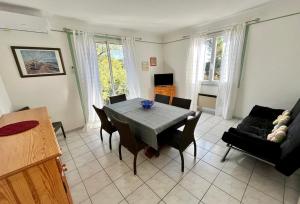 Domaine Des Mimosas في أرجيليه سور مير: غرفة معيشة مع طاولة وكراسي وأريكة