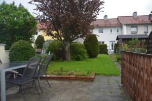 a patio with a table and chairs in a yard at Cozy house with garden in Kaufbeuren