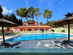 een zwembad met stoelen en een huis bij Domaine Des Mimosas in Argelès-sur-Mer