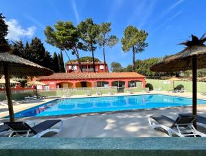 a swimming pool with chairs and a house at Domaine Des Mimosas in Argelès-sur-Mer