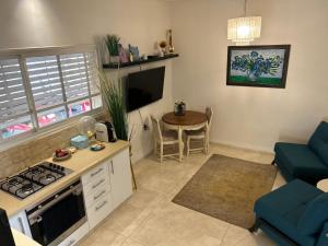 a kitchen and living room with a stove and a table at לארח, זה בטבע שלנו in Kfar Blum