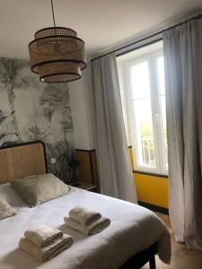 een slaapkamer met een bed met twee handdoeken erop bij DOMAINE DU GRAND CAUGY in Saint-Vigor-le-Grand