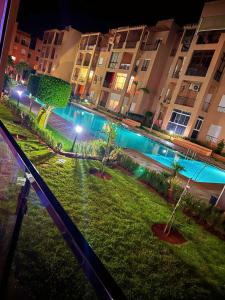 a view of a park with trees and buildings at night at Reco flores PALM in Ben Slimane