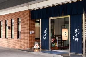 un negozio davanti a casa con scritte sulle porte di un edificio di Monogusa no Yado Hanasenkyo a Nikko