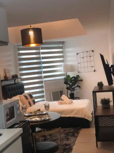 a bedroom with a bed and a table and a window at Resort Condo Unit with Stunning View - Azure North in Lagundi