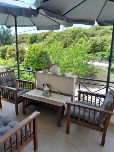 a patio with a table and chairs and an umbrella at FAMILY HOUSE in Kavala