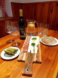 a wooden table with wine glasses and meat and cheese at Penzion Tereza in Telnice