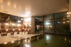 um átrio com piscina e cadeiras num edifício em Monogusa no Yado Hanasenkyo em Nikko