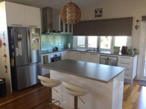 a kitchen with a large island with two stools at Surfside Escape in Surf Beach