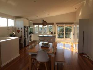 a living room with a table and a kitchen at Surfside Escape in Surf Beach +23 photos