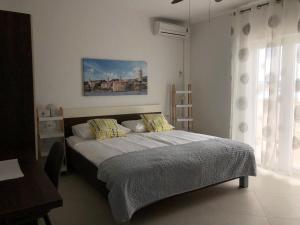 Schlafzimmer mit einem Bett und einem Fenster in der Unterkunft Apartments Aco in Barbat na Rabu
