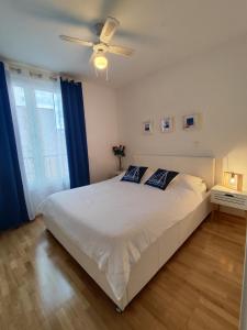 - une chambre avec un lit blanc et un ventilateur de plafond dans l'établissement Beach Pearl Apartment, à Split