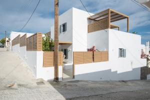 una casa con pareti bianche e balconi in legno di Aba Ηospitalité, The Deluxe Suite, Naousa a Naoussa