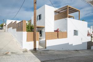 a house with white walls and wooden balconies at Aba Ηospitalité, The Deluxe Suite, Naousa in Naousa