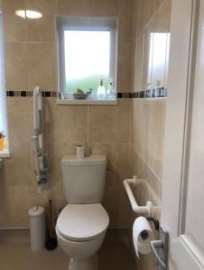 a bathroom with a white toilet and a window at Budget London Room in London