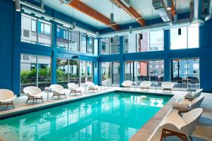een binnenzwembad met stoelen, tafels en ramen bij Element Seattle Redmond in Redmond