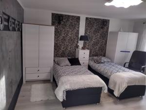 sypialnia z 2 łóżkami i komodą w obiekcie Wodna Dolina Apartament w Koszalinie