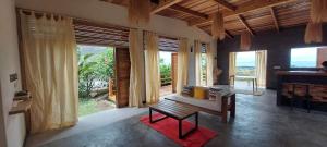a living room with a bench and large windows at RESIDENCE TSARA BE in Nosy Be