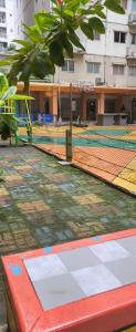 una pista de tenis con red y un parque infantil en Icon gading, en Yakarta
