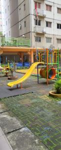 a playground with a yellow slide in a park at Icon gading in Jakarta