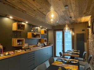 una cucina con tavoli e sedie e una persona in piedi su uno scaffale di Room4You a Oulx