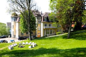 a group of white chairs in the grass in front of a house at Das Kohnstamm in Königstein im Taunus