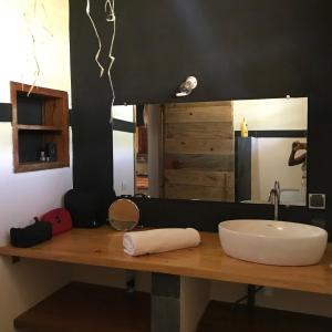 a bathroom counter with a sink and a mirror at RESIDENCE TSARA BE in Nosy Be