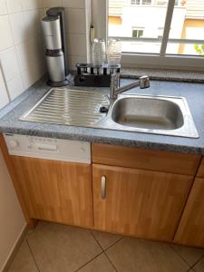 a kitchen counter with a sink next to a window at 60sqm "Piece of heaven" in Munich's south in Munich +33 photos