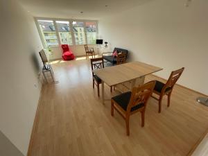 sala de estar con mesa de madera y sillas en 60sqm "Piece of heaven" in Munich's south en Múnich