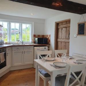 a kitchen with a white table and chairs and a table and chairsktop at Priory Cottage in Westbury