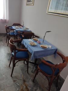 un groupe de tables recouvertes de nappes bleues dans l'établissement Hotel Il Dollaro, à Villa San Giovanni