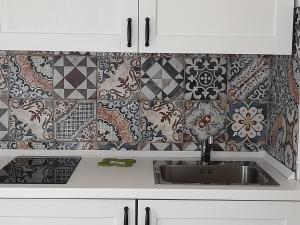cocina con fregadero y azulejos en la pared en APE BIANCA - Appartamento Lavanda, en Colico
