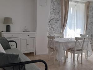 un comedor blanco con mesa y sillas en APE BIANCA - Appartamento Lavanda, en Colico