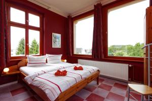 a bedroom with a bed with red walls and windows at Villa Maria Wohnung 07 in Ostseebad Koserow