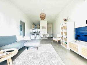 ein Wohnzimmer mit einem blauen Sofa und einem TV in der Unterkunft 2 Minute walk from the Waters Edge in Perth