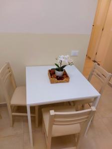 une table et des chaises blanches avec une plante en pot dans l'établissement Bonaini Relax B&B, à Pise