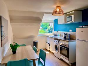 a kitchen with a table and a dining room at F3 La Plage - Gare - Netflix - Wifi - Parking in Évreux