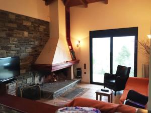 a living room with a fireplace and a tv at Sens de Dieu - Private luxury in Diakopto