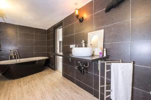 een badkamer met een wastafel, een bad en een spiegel bij Villa Wanderlust Sitges Hills. Exclusive pool. in Olivella
