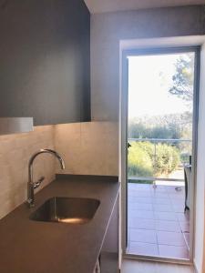een keuken met een wastafel en een glazen schuifdeur bij Villa Wanderlust Sitges Hills. Exclusive pool. in Olivella