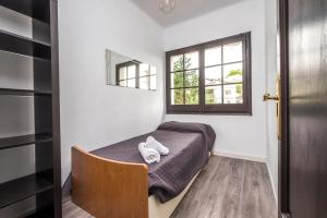 een kleine slaapkamer met een bed en een raam bij Villa Wanderlust Sitges Hills. Exclusive pool. in Olivella