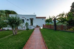 una casa con un patio verde con un camino de ladrillo rojo en Villa with pool & jacuzzi, en Taormina