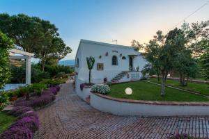 una pequeña casa blanca con un jardín delante de ella en Villa with pool & jacuzzi, en Taormina